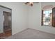 Bedroom with neutral colored walls and carpet and a window with plantation shutters at 9837 W Tonopah Dr, Peoria, AZ 85382