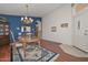 Cozy dining area with hardwood floors, blue accent wall, chandelier, and direct access to front entry at 9837 W Tonopah Dr, Peoria, AZ 85382
