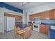 Well-lit kitchen showcasing wood cabinetry, an island with seating, and modern appliances at 9837 W Tonopah Dr, Peoria, AZ 85382