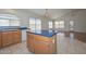 Kitchen featuring an island, tile floors, and a view into the living area at 9837 W Tonopah Dr, Peoria, AZ 85382