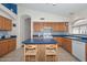 Bright kitchen featuring wood cabinets, an island with seating, and a tiled backsplash at 9837 W Tonopah Dr, Peoria, AZ 85382