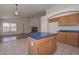 Kitchen island with tile floors and view of living area with fireplace at 9837 W Tonopah Dr, Peoria, AZ 85382