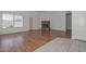 Open living room with brick fireplace, wood floors, and ceiling fan at 9837 W Tonopah Dr, Peoria, AZ 85382