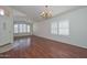 Bright living room featuring wood floors, large windows with shutters, and a decorative chandelier at 9837 W Tonopah Dr, Peoria, AZ 85382