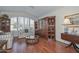 Cozy living room with hardwood floors, a large window, and built-in shelving units at 9837 W Tonopah Dr, Peoria, AZ 85382