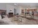Spacious living room featuring hardwood floors, a brick fireplace, and an open layout connecting to the kitchen at 9837 W Tonopah Dr, Peoria, AZ 85382