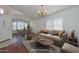 Bright living room featuring hardwood floors, large windows, a beige sofa, and a decorative chandelier at 9837 W Tonopah Dr, Peoria, AZ 85382