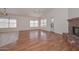 Open living room with brick fireplace, wood floors, and ceiling fan at 9837 W Tonopah Dr, Peoria, AZ 85382