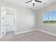 Sunlit bedroom featuring a modern ceiling fan, neutral carpet, and an adjacent bathroom at 1228 N 106Th Pl, Mesa, AZ 85207