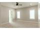 Spacious bedroom with neutral walls, carpet, ceiling fan, and windows with plantation shutters at 1228 N 106Th Pl, Mesa, AZ 85207