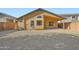 An exterior view of the home and back patio with a gravel filled backyard and perimeter walls at 12333 W Marshall Ave, Litchfield Park, AZ 85340