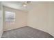 Welcoming bedroom featuring plush gray carpeting, a ceiling fan, and a window at 12333 W Marshall Ave, Litchfield Park, AZ 85340