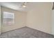 Comfortable bedroom with neutral walls, gray carpet, a ceiling fan, and large window at 12333 W Marshall Ave, Litchfield Park, AZ 85340