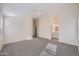 Spacious bedroom with neutral walls, gray carpet, a ceiling fan, and access to an ensuite bathroom at 12333 W Marshall Ave, Litchfield Park, AZ 85340