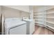 Bright laundry room with lots of storage on shelves and two appliances at 12333 W Marshall Ave, Litchfield Park, AZ 85340