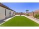 Beautiful backyard featuring a green lawn, pavers, and desert landscaping for outdoor enjoyment at 13196 W Coronado Rd, Goodyear, AZ 85395