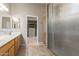 Bathroom featuring a dual sink vanity, a glass shower, and an open doorway leading into the closet at 13196 W Coronado Rd, Goodyear, AZ 85395