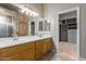 Bathroom showcasing dual sinks, a vanity, a glass shower, and a closet with custom shelving and storage at 13196 W Coronado Rd, Goodyear, AZ 85395