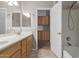 Bathroom featuring dual sinks, wood cabinets, a tiled floor, and an alcove bathtub with a shower head at 13196 W Coronado Rd, Goodyear, AZ 85395