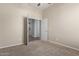 Bedroom with neutral carpet, neutral walls, a ceiling fan, and a door leading to another room at 13196 W Coronado Rd, Goodyear, AZ 85395