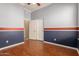 This bedroom boasts beautiful flooring, half wall paint design, and access to the home at 13196 W Coronado Rd, Goodyear, AZ 85395