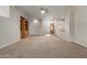 Spacious living room with neutral carpet, ceiling fan, and wood shelving unit at 13196 W Coronado Rd, Goodyear, AZ 85395