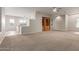 Expansive living room featuring neutral carpet, ceiling fan and built-in wood shelving at 13196 W Coronado Rd, Goodyear, AZ 85395