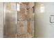 Close-up of a shower with tiled walls, glass door, and a shower head with a built-in niche at 13196 W Coronado Rd, Goodyear, AZ 85395