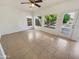 Open-concept living room with tile flooring, large windows, and access to backyard at 1360 E Washington Ave, Gilbert, AZ 85234