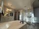 Bright bathroom featuring a shower, soaking tub, and double sinks with a view of the shower at 15620 W Cameron Dr, Surprise, AZ 85379