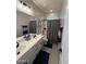 Bathroom featuring double sinks and a shower, designed for convenience at 15620 W Cameron Dr, Surprise, AZ 85379