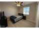 Bedroom features a window, ceiling fan, wood-look flooring, bed and a dresser at 15620 W Cameron Dr, Surprise, AZ 85379