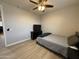 Bedroom features a bed, dresser, wood-look flooring, and modern ceiling fan at 15620 W Cameron Dr, Surprise, AZ 85379
