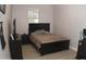 Well-lit bedroom features a black bed frame and wood-look floors, offering a cozy retreat at 15620 W Cameron Dr, Surprise, AZ 85379