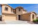 A charming two-story home with a stone-accented entrance, a three-car garage, and a paved driveway at 15620 W Cameron Dr, Surprise, AZ 85379