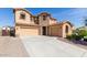 Two-story home featuring a stone facade, three-car garage, and a well-maintained front yard at 15620 W Cameron Dr, Surprise, AZ 85379