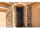 A close-up of the detailed stone work around the elegant, wrought iron front door at 15620 W Cameron Dr, Surprise, AZ 85379