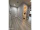 Hallway with wood-look floors leading to a bathroom and bedroom, showcasing the home's inviting layout at 15620 W Cameron Dr, Surprise, AZ 85379