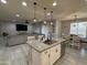 Stylish kitchen island with granite countertops, pendant lighting, and seating, open to the living area at 15620 W Cameron Dr, Surprise, AZ 85379
