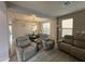 Open-concept living area with modern furniture, wood floors, and seamless dining room access at 15620 W Cameron Dr, Surprise, AZ 85379