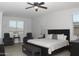 This main bedroom is decorated with 2 arm chairs, a ceiling fan, and many large windows at 15620 W Cameron Dr, Surprise, AZ 85379