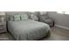 Comfortable bedroom featuring a queen bed with decorative pillows, side tables, and a relaxing armchair at 15620 W Cameron Dr, Surprise, AZ 85379