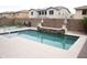 Outdoor pool area with a water feature, desert landscaping, and patio seating at 15620 W Cameron Dr, Surprise, AZ 85379