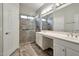 Bright bathroom featuring a large vanity with double sinks and a tiled walk-in shower at 15834 W Avalon Dr, Goodyear, AZ 85395