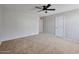 Spacious carpeted bedroom with a ceiling fan and two doors for easy access at 15834 W Avalon Dr, Goodyear, AZ 85395