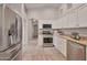 Well-lit kitchen featuring stainless steel appliances, granite countertops, and tile floors at 15834 W Avalon Dr, Goodyear, AZ 85395