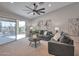 Comfortable living room with sliding glass doors to the backyard and a ceiling fan at 15834 W Avalon Dr, Goodyear, AZ 85395