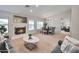 Open-concept living room with fireplace, neutral decor, and seamless flow into dining area at 15834 W Avalon Dr, Goodyear, AZ 85395