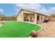 Well maintained backyard featuring low maintenance landscaping, artificial turf, and desert rock at 16187 W Gibson Ln, Goodyear, AZ 85338