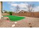 Low maintenance backyard with artificial turf, desert landscaping, and a block wall fence for privacy at 16187 W Gibson Ln, Goodyear, AZ 85338